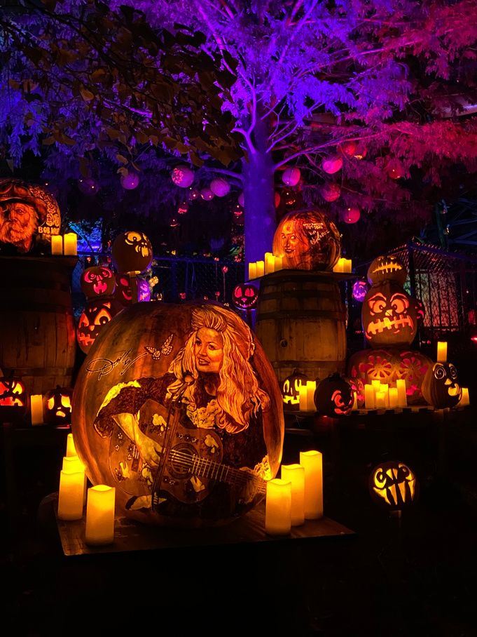 Carved, glowing jack-o'-lanterns lit purple and orange at night